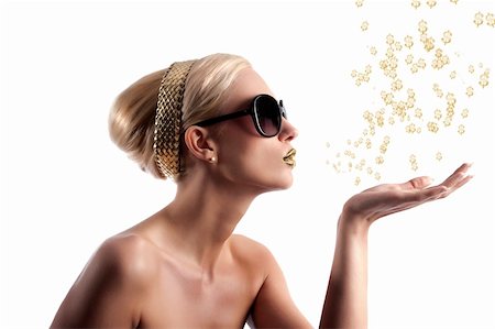 simsearch:400-04330316,k - blond young woman in beauty shot looking on one side and blowing some golden star from her hand Foto de stock - Super Valor sin royalties y Suscripción, Código: 400-05387856