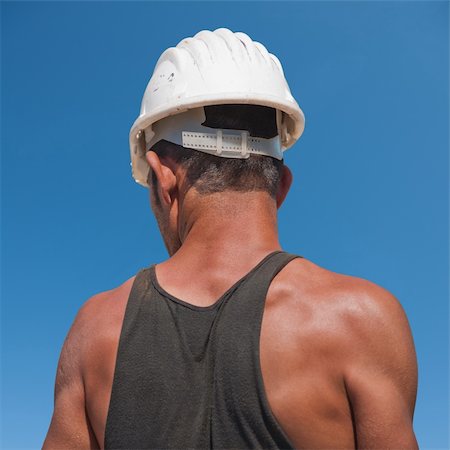 Back of construction worker against blue sky Foto de stock - Super Valor sin royalties y Suscripción, Código: 400-05380822