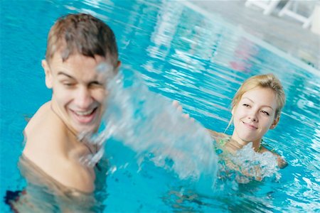 Happy teenage couple splashing at the swimming pool Stock Photo - Budget Royalty-Free & Subscription, Code: 400-05381218