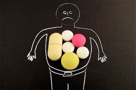 Man with belly full of pills on blackboard Stock Photo - Budget Royalty-Free & Subscription, Code: 400-05383948