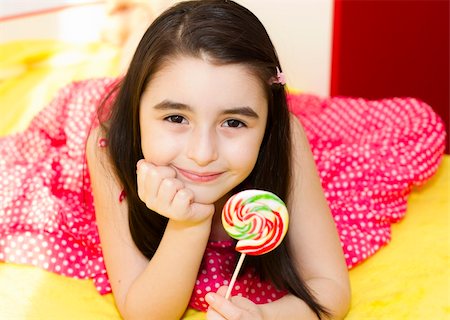 Little girl with lollipop in her bedroom. Foto de stock - Super Valor sin royalties y Suscripción, Código: 400-05665515