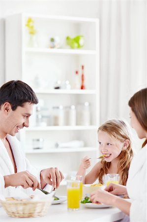 A happy family with a child eating breakfast in the kitchen Stock Photo - Budget Royalty-Free & Subscription, Code: 400-05668688