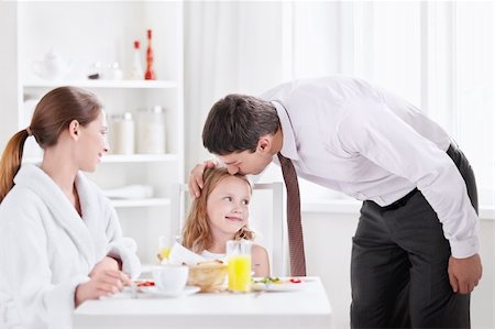 The father kisses his daughter before leaving the kitchen Stock Photo - Budget Royalty-Free & Subscription, Code: 400-05668703