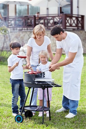 simsearch:400-05668741,k - Happy family cooks sausages outdoors Photographie de stock - Aubaine LD & Abonnement, Code: 400-05668742