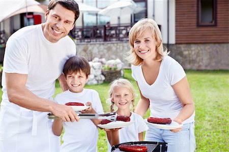 simsearch:400-05668741,k - Smiling family with children at barbecue Photographie de stock - Aubaine LD & Abonnement, Code: 400-05668755