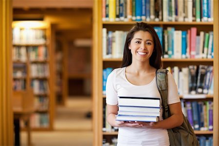 school girl holding pile of books - Student holding books in the library Stock Photo - Budget Royalty-Free & Subscription, Code: 400-05668882