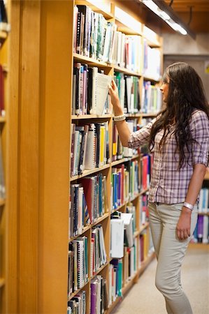 simsearch:400-05678093,k - Portrait of a young woman choosing a book in a library Stock Photo - Budget Royalty-Free & Subscription, Code: 400-05668932