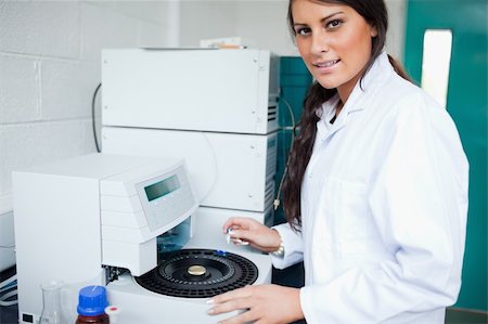 Serious laboratory assistant using a centrifuge while looking at the camera Fotografie stock - Microstock e Abbonamento, Codice: 400-05669752