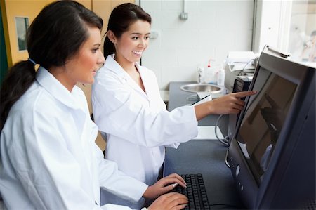 scientist pointing image - Cute scientists working with a monitor in a laboratory Stock Photo - Budget Royalty-Free & Subscription, Code: 400-05669785