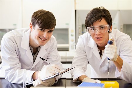 funnel - Handsome scientists making an experiment while looking at the camera Stock Photo - Budget Royalty-Free & Subscription, Code: 400-05669780