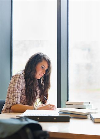 simsearch:400-05678140,k - Portrait of a serious student writing in a library Stockbilder - Microstock & Abonnement, Bildnummer: 400-05669857