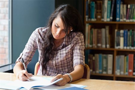 simsearch:400-05678093,k - Young student writing in a library Stock Photo - Budget Royalty-Free & Subscription, Code: 400-05669939