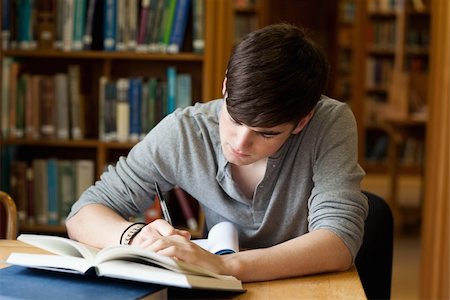 simsearch:400-05678093,k - Focused male student working in a library Stock Photo - Budget Royalty-Free & Subscription, Code: 400-05669979