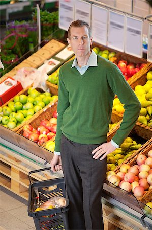 simsearch:400-04851035,k - Serious man with hand on hip looking at camera while shopping in a fruit store Photographie de stock - Aubaine LD & Abonnement, Code: 400-05663592