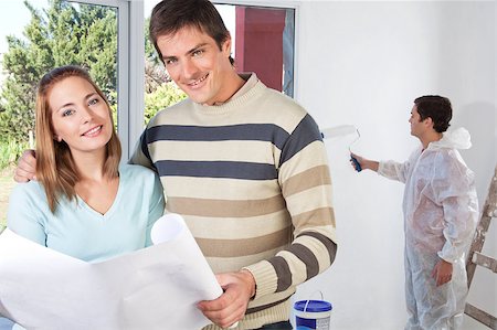 Portrait of happy couple together while painter painting the wall Stock Photo - Budget Royalty-Free & Subscription, Code: 400-05663604