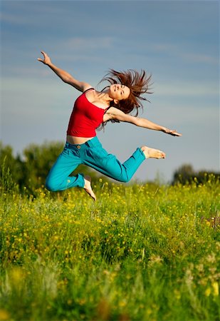 Happy young woman in sport wear jumping on a sunset field Fotografie stock - Microstock e Abbonamento, Codice: 400-05674488