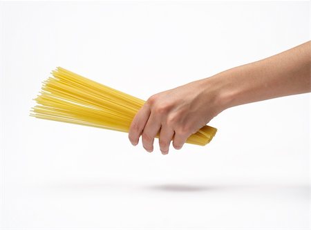 Woman's hand holding bunch of spaghetti.  Isolated on a white background. Fotografie stock - Microstock e Abbonamento, Codice: 400-05674500