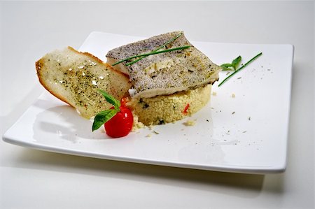 Pike-perch fillet garnished with vegetables and toast, served on white plate Fotografie stock - Microstock e Abbonamento, Codice: 400-05674533