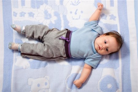 Male newborn baby lying on a bed on a blue bedspread. Stock Photo - Budget Royalty-Free & Subscription, Code: 400-05675057