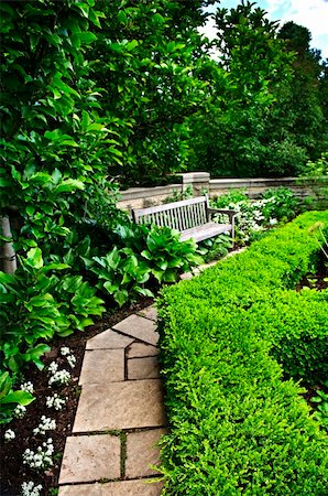 simsearch:400-06892144,k - Lush green garden with stone landscaping, hedge, path and bench Stockbilder - Microstock & Abonnement, Bildnummer: 400-05677047