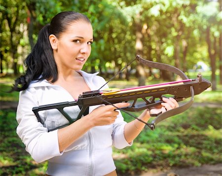 beautiful young girl with arbalest on the wood background Stock Photo - Budget Royalty-Free & Subscription, Code: 400-05677294