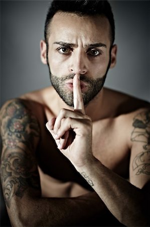 fauchen - portrait of proud young adult man with tattoos hissing. Vertical shape, front view, studio shot Stockbilder - Microstock & Abonnement, Bildnummer: 400-05677672