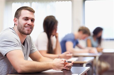 simsearch:400-05677834,k - Smiling young man sitting in a classroom Photographie de stock - Aubaine LD & Abonnement, Code: 400-05677805