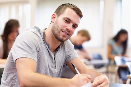 Smiling young adult writing in a classroom Stock Photo - Budget Royalty-Free & Subscription, Code: 400-05677814