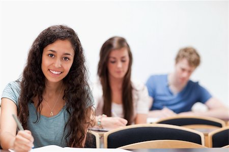 simsearch:400-05684337,k - Smiling young students sitting in a classroom Foto de stock - Royalty-Free Super Valor e Assinatura, Número: 400-05677816