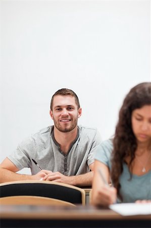 simsearch:400-05684337,k - Portrait of a smiling handsome student in an amphitheater Photographie de stock - Aubaine LD & Abonnement, Code: 400-05677824