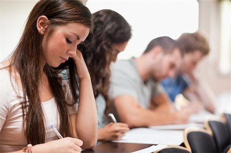 simsearch:400-05684337,k - Serious students listening a lecturer in an amphitheater Foto de stock - Royalty-Free Super Valor e Assinatura, Número: 400-05677836