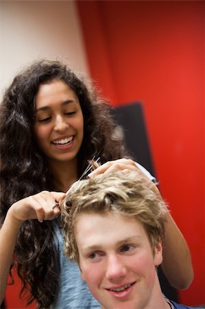 Portrait of a female hairdresser cutting hair while smiling Stock Photo - Budget Royalty-Free & Subscription, Code: 400-05677949