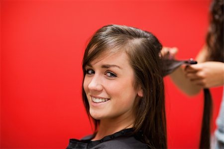 enderezando - Young woman having her hair straightened while looking at the camera Foto de stock - Super Valor sin royalties y Suscripción, Código: 400-05677975
