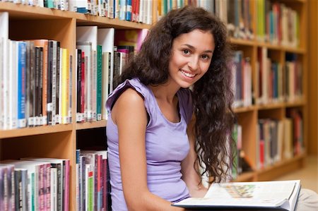 simsearch:400-05678093,k - Young student holding a book in a library Stock Photo - Budget Royalty-Free & Subscription, Code: 400-05678042