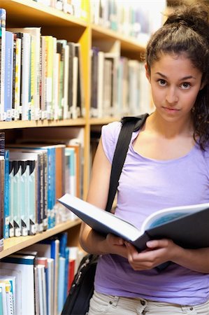 simsearch:400-05678140,k - Portrait of a serious female student holding a book in a library Stockbilder - Microstock & Abonnement, Bildnummer: 400-05678136