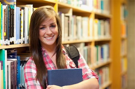 simsearch:400-05678140,k - Smiling female student posing in a library Stockbilder - Microstock & Abonnement, Bildnummer: 400-05678132