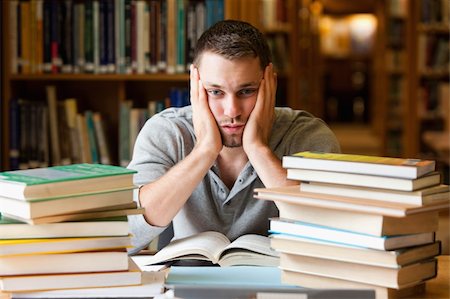 simsearch:400-05668910,k - Depressed student having a lot to read looking at the camera Stock Photo - Budget Royalty-Free & Subscription, Code: 400-05678149