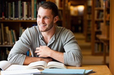 simsearch:400-05678140,k - Smiling male student working in a library Stockbilder - Microstock & Abonnement, Bildnummer: 400-05678140