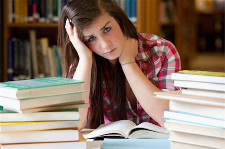 simsearch:400-04622035,k - Depressed student surrounded by books looking at the camera Stock Photo - Budget Royalty-Free & Subscription, Code: 400-05678152