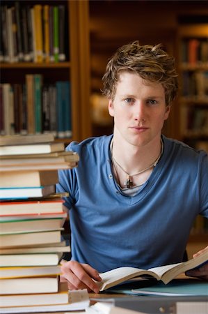 simsearch:700-01345048,k - Portrait of a male student posing with books in a library Fotografie stock - Microstock e Abbonamento, Codice: 400-05678162