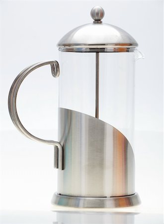 Brushed metal stainless steel and glass coffee plunger against a light background and on a reflective white table top Foto de stock - Super Valor sin royalties y Suscripción, Código: 400-05679527