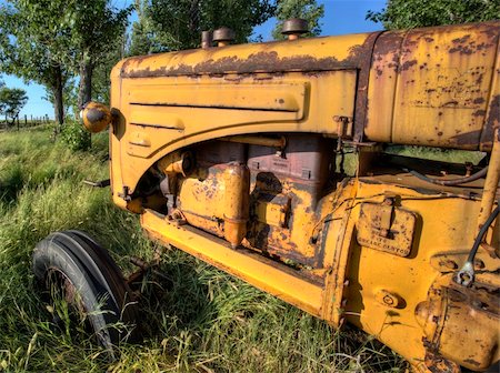 simsearch:400-07429043,k - Old Vintage Farm tractor Saskatchewan Canada yellow Foto de stock - Royalty-Free Super Valor e Assinatura, Número: 400-05679857