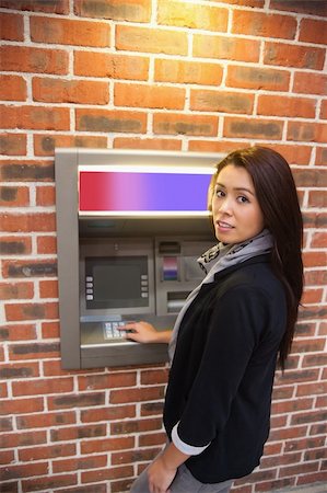 Portrait of a woman withdrawing cash at an ATM Fotografie stock - Microstock e Abbonamento, Codice: 400-05670017