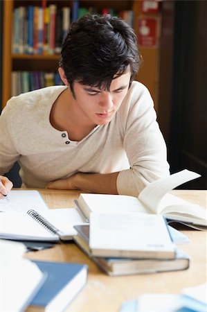 simsearch:400-05669803,k - Portrait of a serious student writing an essay in a library Photographie de stock - Aubaine LD & Abonnement, Code: 400-05670046