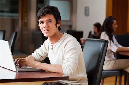 simsearch:400-03996848,k - Handsome man using a laptop while looking at the camera Fotografie stock - Microstock e Abbonamento, Codice: 400-05670105