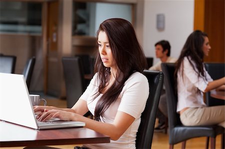 simsearch:400-04504422,k - Jeune femme à l'aide d'un ordinateur portable dans un café Photographie de stock - Aubaine LD & Abonnement, Code: 400-05670100