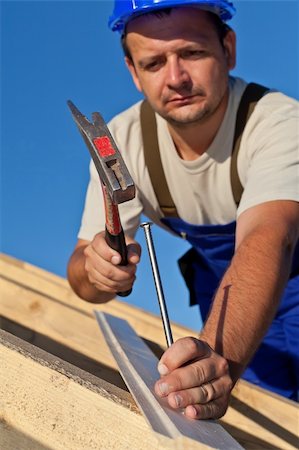 roof hammer - Carpenter working on the roof driving a nail in - shallow depth Stock Photo - Budget Royalty-Free & Subscription, Code: 400-05670245