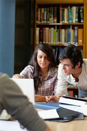 simsearch:400-06557512,k - Portrait of smiling students working together in a library Photographie de stock - Aubaine LD & Abonnement, Code: 400-05670284