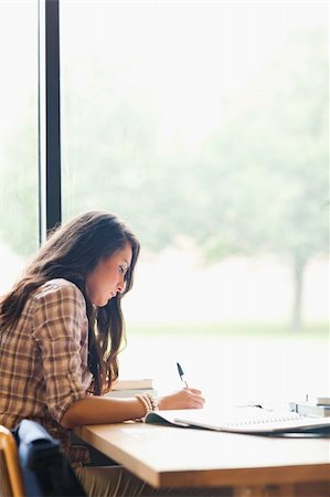 simsearch:400-05678093,k - Portrait of a serious young student writing an essay in a library Stock Photo - Budget Royalty-Free & Subscription, Code: 400-05670300