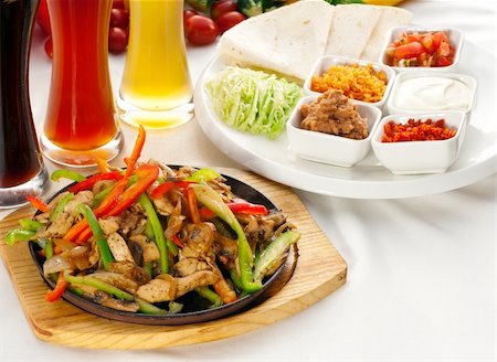 sauce tomate verte piquante - original fajita sizzling smoking hot served on iron plate ,with selection of beer and fresh vegetables on background ,MORE DELICIOUS FOOD ON PORTFOLIO Photographie de stock - Aubaine LD & Abonnement, Code: 400-05670319